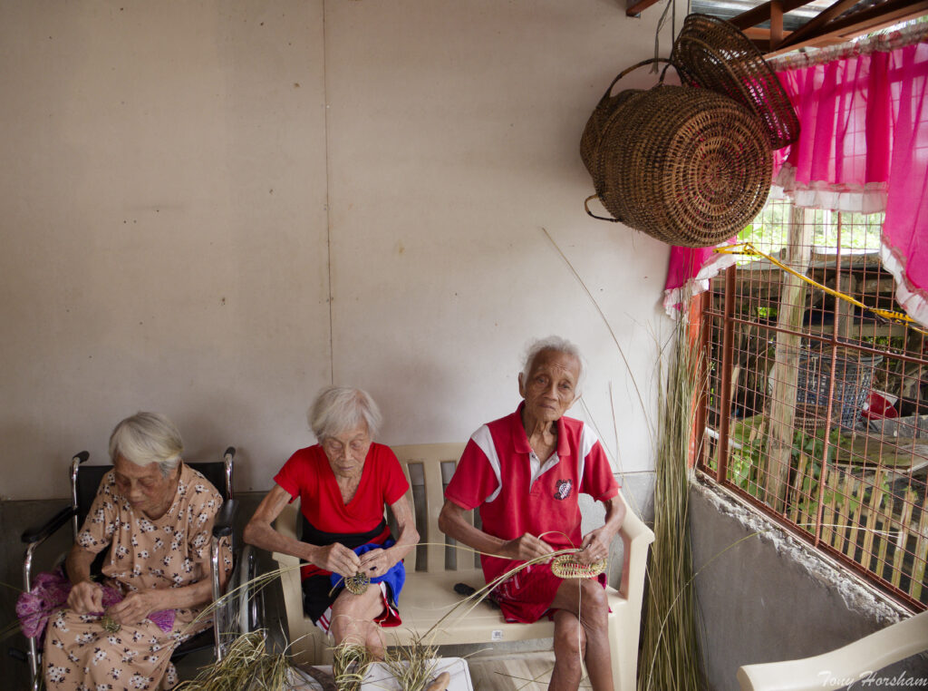 Three siblings weaving baskets